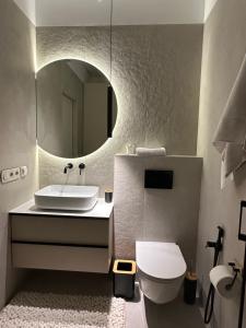 een badkamer met een wastafel, een toilet en een spiegel bij Other Apartments in Ivano-Frankivsʼk