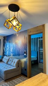 a living room with a couch and a bedroom at Natural White apartments in Bjelašnica