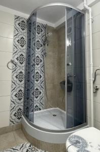y baño con ducha y puerta de cristal. en Hestia Lux, en Cluj-Napoca