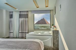 uma casa de banho com uma banheira e uma pirâmide em Khan Duidar Inn - Pyramids View Rooftop em Cairo