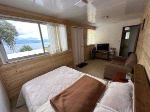 1 dormitorio con cama, sofá y ventana en La Puerta Del Lago ECOPARQUE, en Tota