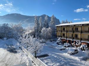 a hotel with snow covered trees and a building at Hôtel Lacour in Eygliers