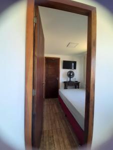 a room with a bed and a mirror at Apartamento Container 1 quarto- Centro Garopaba in Garopaba