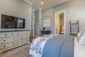 a bedroom with a bed and a dresser with a television at Couples Retreat, Walk to waterfront, shops and restaurants! in Beaufort