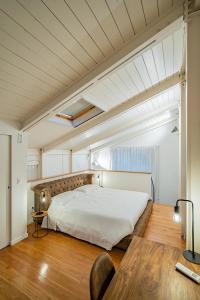 1 dormitorio con 1 cama grande y suelo de madera en Anfihouse - Assisi Relais, en Asís