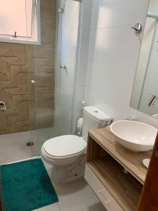 uma casa de banho com um WC, um lavatório e um chuveiro em Apê Carla Valéria em Ubatuba