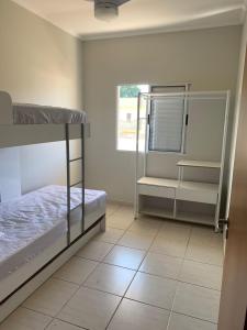 1 dormitorio con 2 literas y suelo de baldosa en Apê Carla Valéria, en Ubatuba