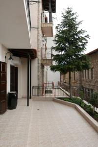 une cour avec un arbre à côté d'un bâtiment dans l'établissement Aimilias House, Διαμέρισμα δυο υπνοδωματίων, à Arachova