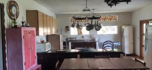 uma cozinha com uma mesa de madeira e uma cozinha com uma mesa; em Sitio na Serra da Mantiqueira Águas do Canjarana em São Francisco Xavier