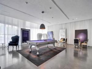 a living room with a pool table and chairs at 2 Bedroom with stunning views at the W residences in Miami