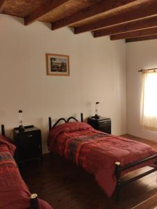 a bedroom with a bed and two night stands and a window at Alojamiento turístico NFG in San Carlos de Bariloche