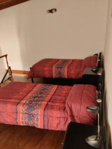 a bedroom with two beds and a table with a lamp at Alojamiento turístico NFG in San Carlos de Bariloche