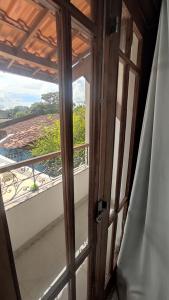 an open door with a view of a balcony at Casa da alegria 4 quartos centro histórico in Itaparica