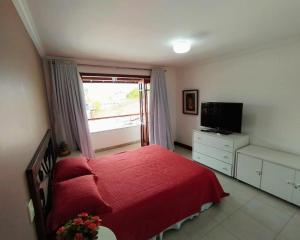 a bedroom with a red bed and a window at Casa da alegria 4 quartos centro histórico in Itaparica
