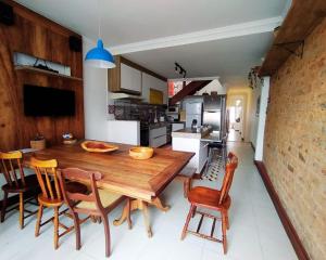 a kitchen and dining room with a wooden table and chairs at Casa da alegria 4 quartos centro histórico in Itaparica
