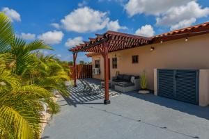 a patio with a pergola in front of a house at Felicidad 30 in Oranjestad
