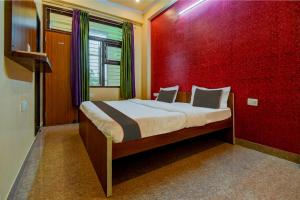 齋浦爾的住宿－OYO Flagship Hotel Mohi Palace，一间卧室配有一张红色墙壁的床