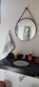 a bathroom with a mirror and a sink at Guedes Residence in Ilha de Boipeba