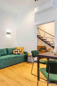 a living room with a green couch and a table at Elegant Stay Near Hungarian Museum by Pink Flamingo in Budapest