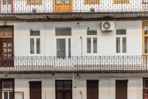 a white building with a balcony and a clock on it at Elegant Stay Near Hungarian Museum by Pink Flamingo in Budapest