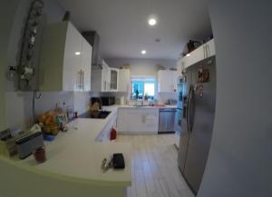 una cucina con armadietti bianchi e frigorifero di Cozy room in a quiet home a Miami