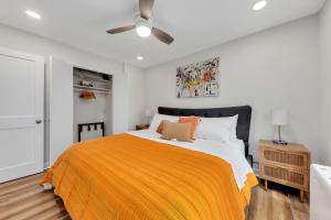 a bedroom with a bed with an orange blanket at Downtown Condo Walk To Mercedes Benz Stadium in Atlanta