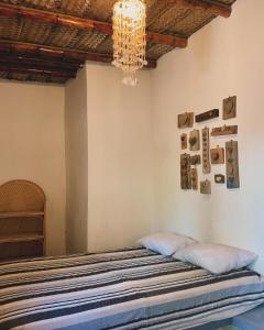 1 dormitorio con cama y lámpara de araña en Naif habitaciones en Máncora
