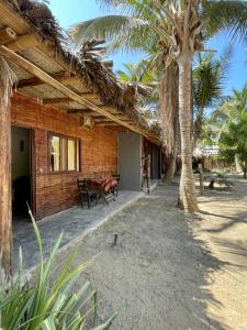 una casa en la playa con una palmera en Naif habitaciones, en Máncora