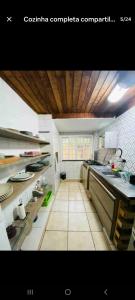 a large kitchen with white counters and a wooden ceiling at HostelAmaréStar Sempremovimento in Rio de Janeiro