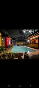 a large swimming pool at night with a red building at HostelAmaréStar Sempremovimento in Rio de Janeiro