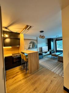 別拉什尼察的住宿－Natural White apartments，厨房以及带桌椅的起居室。