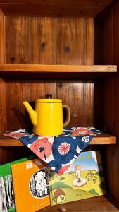 a yellow pot sitting on a shelf with a book at Yamaharuka in Jinhu