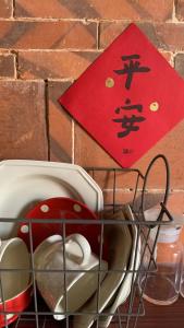 eine rote Karte an einer Backsteinwand neben einem Korb in der Unterkunft Yamaharuka in Jinhu