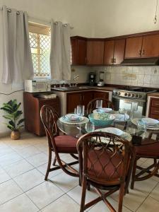 a kitchen with a table and chairs and a kitchen with a stove at Departamento en el Área de Olas Altas in Mazatlán