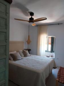 a bedroom with a bed with a ceiling fan at La Niña de Vejer in Vejer de la Frontera