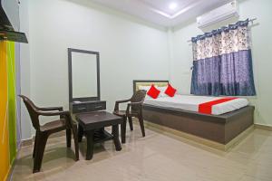 Schlafzimmer mit einem Bett, einem Schreibtisch und einem Spiegel in der Unterkunft OYO Flagship Hotel Mh31 in Nagpur