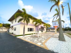 克利尔沃特Studio Apt W 2q Beds & Shared Pool 01的街道前有棕榈树的建筑