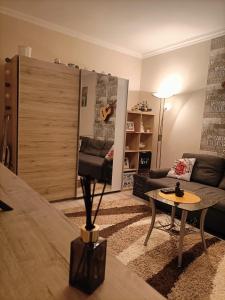 uma sala de estar com um sofá e uma mesa em Hírös Home em Kecskemét
