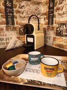 a table with two coffee cups and a toaster at Hírös Home in Kecskemét