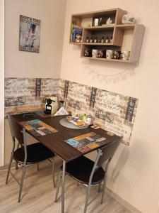 a dining room table with two chairs in a room at Hírös Home in Kecskemét