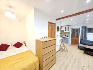 a bedroom with a yellow bed and a dresser at Studio apartment, TV, WiFi Kitchen Parking, Wembley Elizabeth Line in Northolt