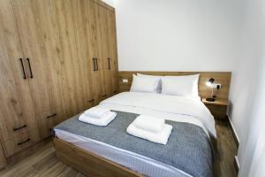 ein Schlafzimmer mit einem großen Bett und zwei weißen Handtüchern in der Unterkunft Airbnb Kastoria - Bella Vista A in Kastoria