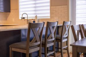 a kitchen with a row of chairs at a counter at Riverside Condos by Fernie Central Reservations in Fernie