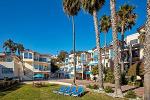 a row of apartment buildings with lounge chairs and palm trees at Seaport Village Inn, Avalon in Avalon