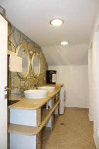 dwie umywalki w łazience z dwoma lustrami na ścianie w obiekcie Къща за гости "При Николови" w mieście Beden