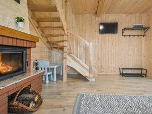 ein Wohnzimmer mit einem Kamin und einer Treppe in der Unterkunft Spiska Chatka in Kacwin