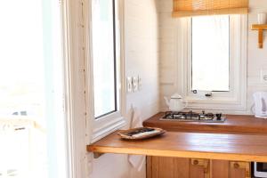 a kitchen with a counter with a stove and a window at Cabaña Sal de Mar in Punta Del Diablo
