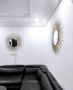 een woonkamer met een bank en 2 spiegels bij Residence Sighaka - Luxus VIP Apartment - WiFi, Gardien, Parking in Douala