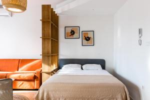 a bedroom with a bed and a leather couch at The Riverscape in Podgorica