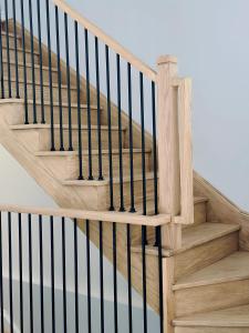 an image of a wooden staircase with black railings at 112 Delphi Court - Blue Mountain Escape in Blue Mountains